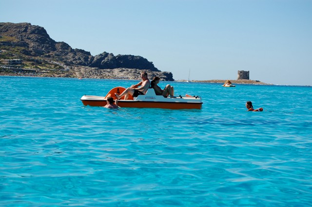 Al largo, scivola supra sa stupenda acqua azzurrissima del mare, il pedalo' con qualche coraggioso a bordo.